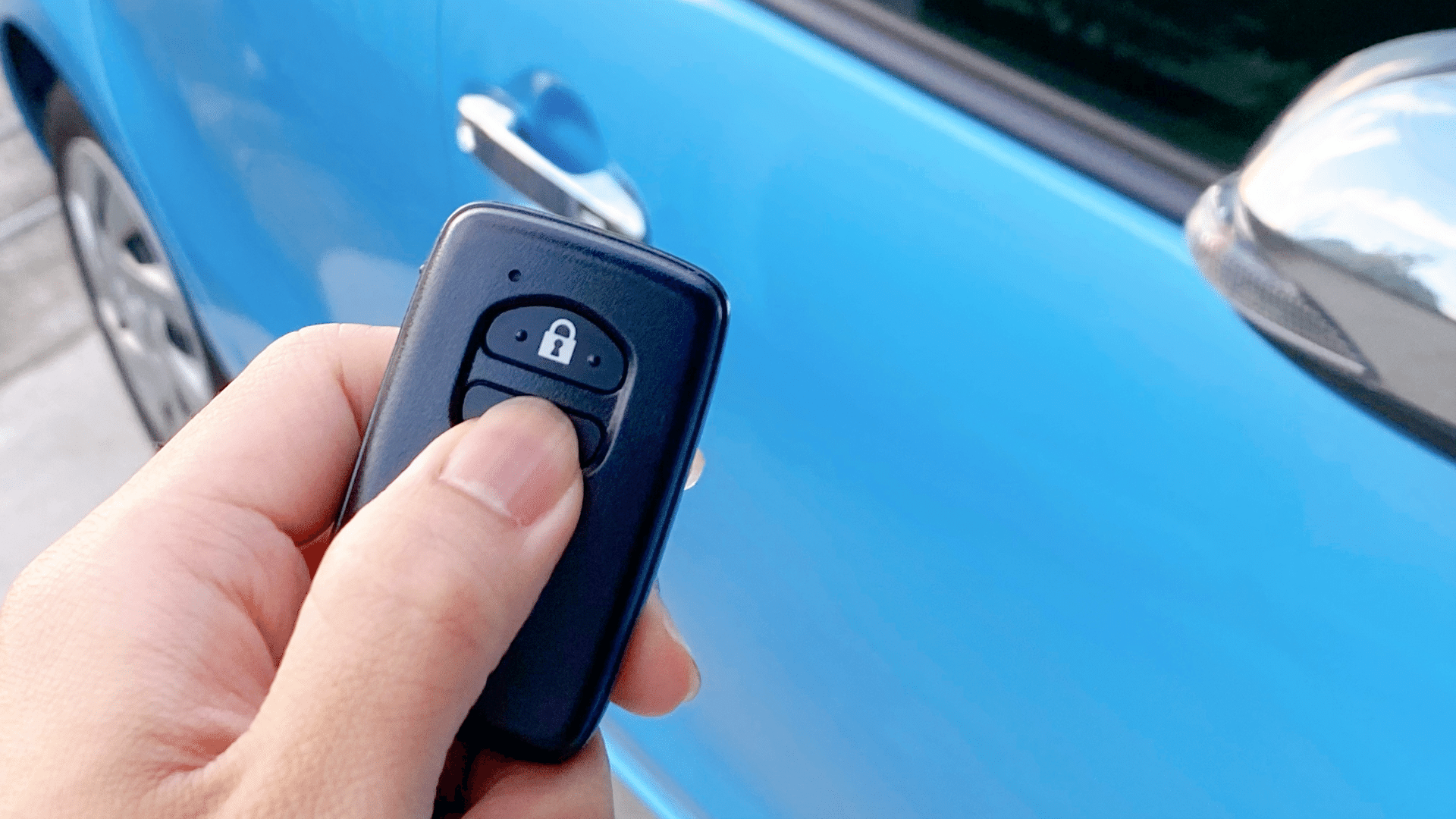 Toyota Smart Key In Hand With Car In Background Image